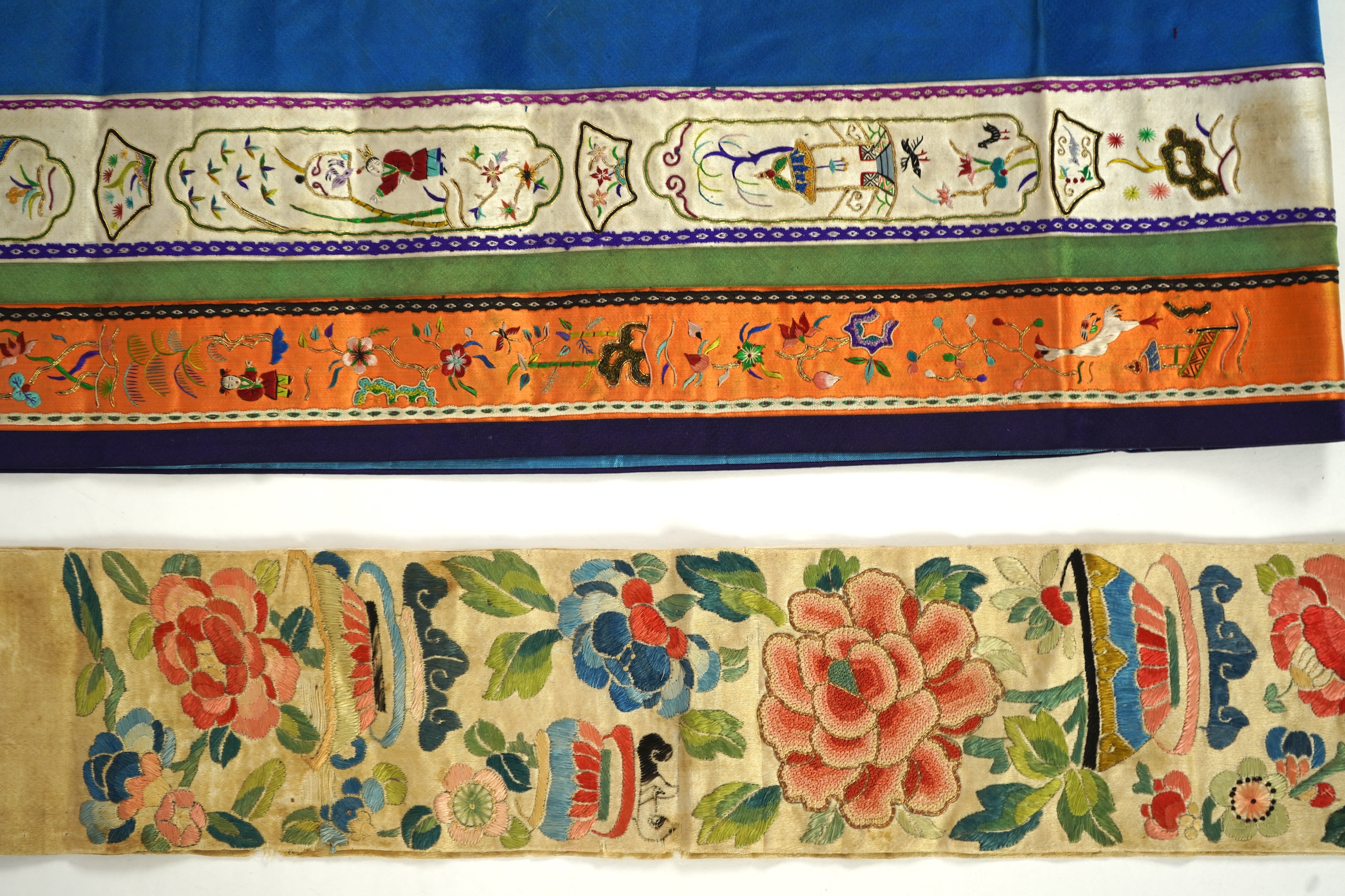 A Chinese embroidered silk panel of uncut robe borders, eleven similar sleeve panels and two other items, late Qing dynasty